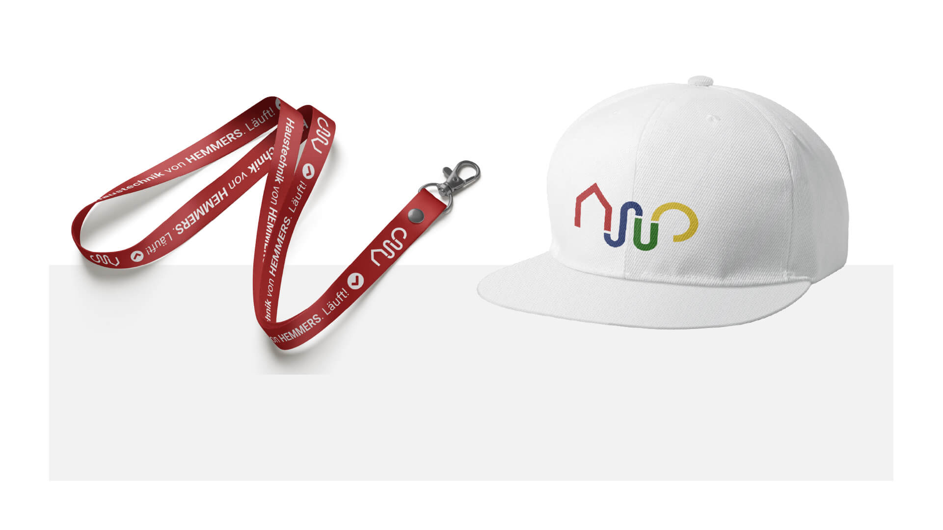 Logo von Hemmers Haustechnik auf einem Lanyard und einer Cap